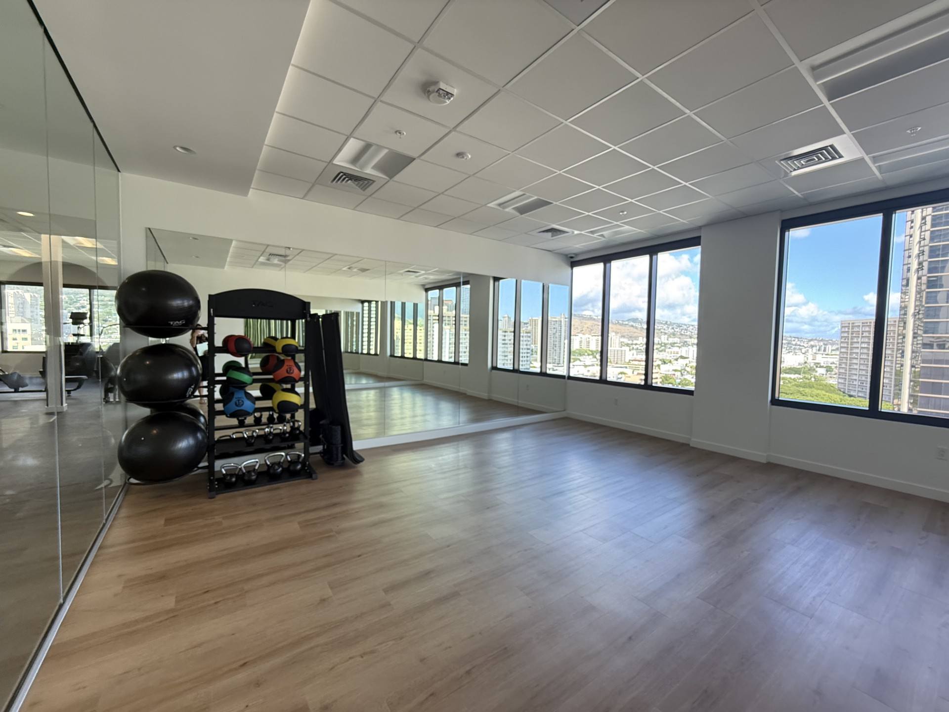 A room with wooden floors and a large window overlooking a cityscape.